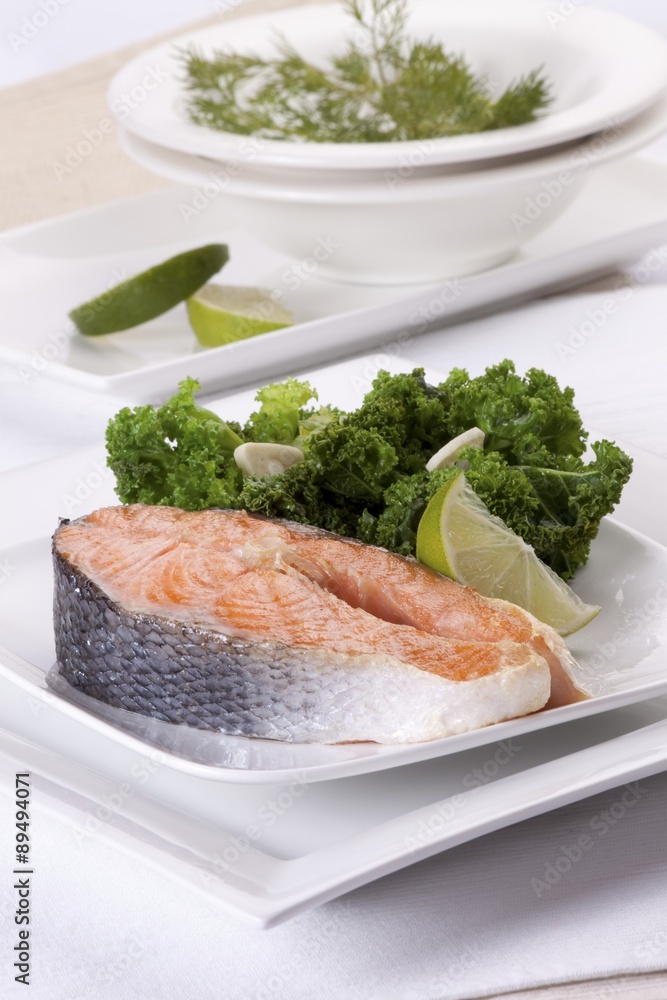 Raw salmon steak with green cabbage and a lemon wedge Raw salmon steak with green cabbage and a lemon wedge
