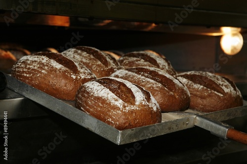 Freshly baked rye bread being removed from the oven