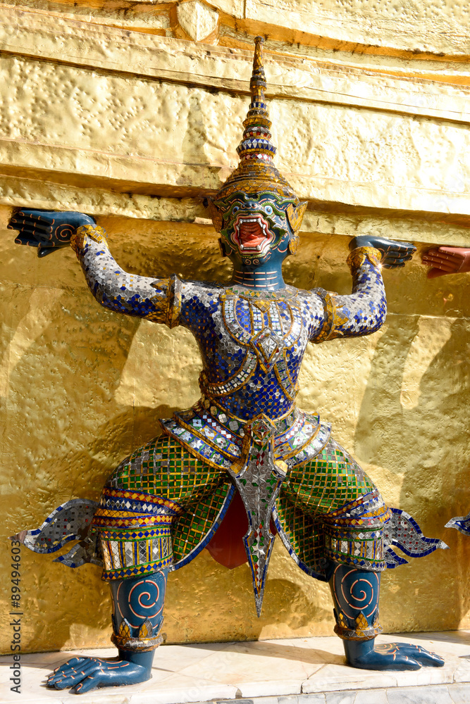 Guardian demon holding Golden Chedi of Wat Phra Kaew Temple in Bangkok, Thailand.