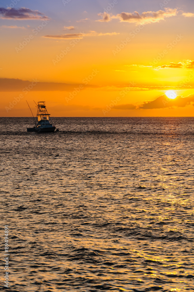 Beautiful sunset behind sport fishing boat on Maui, Hawaii, USA