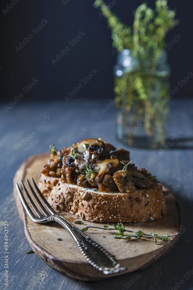 Mushroom, Sausage and Thyme Crostini on a Small Cutting Board; Fork Mushroom, Sausage and Thyme Crostini on a Small Cutting Board; Fork