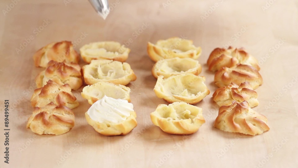 Profiteroles being filled with cream Profiteroles being filled with cream