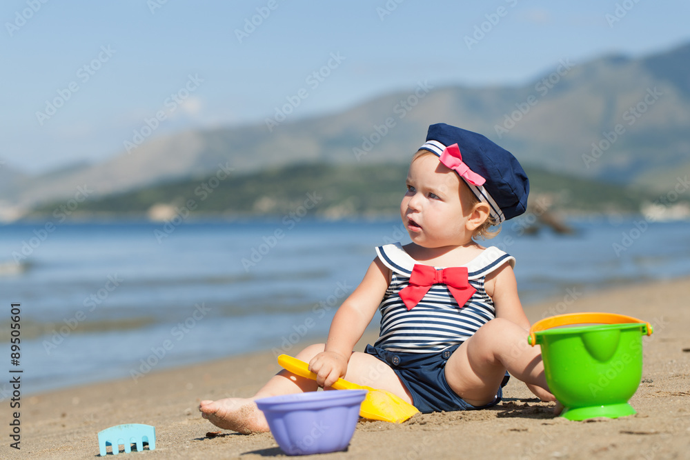 Happy cute girl in swimsuit playing with sand on beach Happy cute girl in swimsuit playing with sand on beach