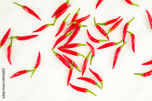 Spicy red Thai chili peppers scattered across white background.