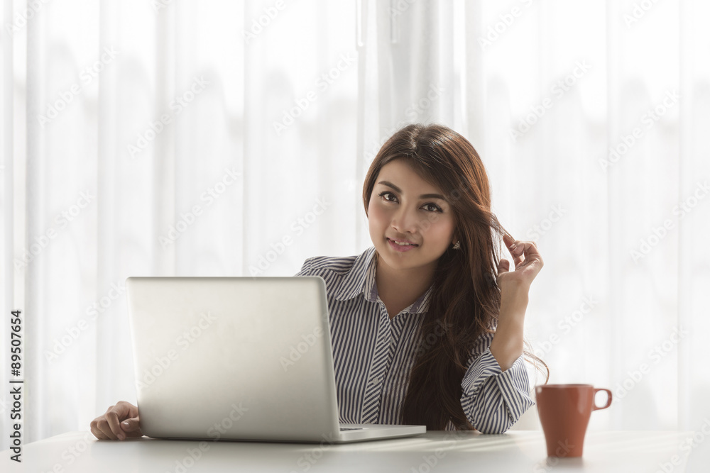Beautiful young asian woman using laptop at home