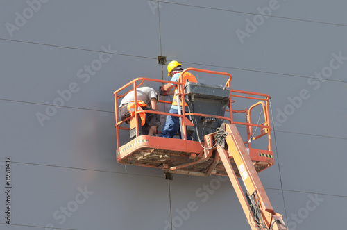 Workers in lifting cage photo