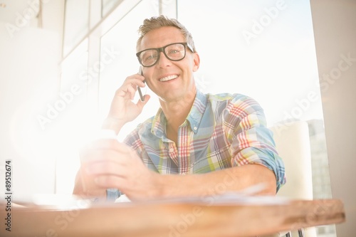 Smiling casual designer having a phone call