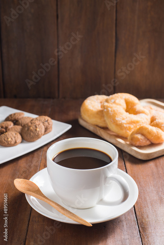 Coffee cup, donuts, cookie on wooden background