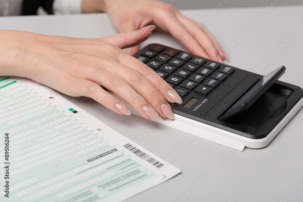 Hand mit Taschenrechner und Steuererklärung Hand mit Taschenrechner und Steuererklärung
