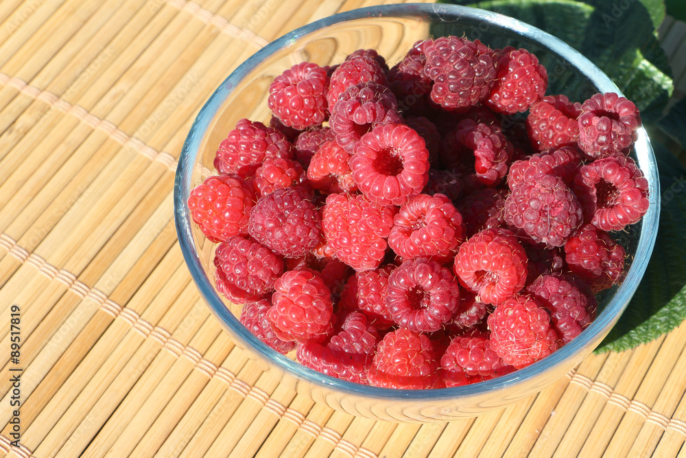 Basket with fresh ripe raspberries standing on a table in a garden
Basket with fresh ripe raspberries standing on a table in a garden