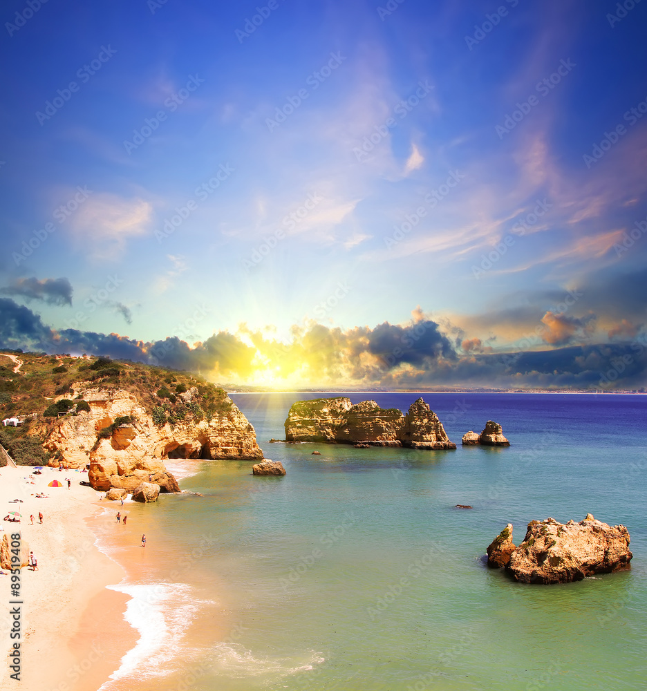 Rocky beach at sunset, Lagos, Portugal. Counter light. Travel and business background