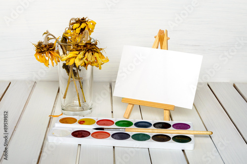 bouquet of dried sunflowers, easel and paints photo