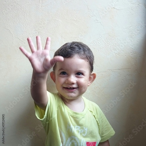 Niño saludando con la mano
