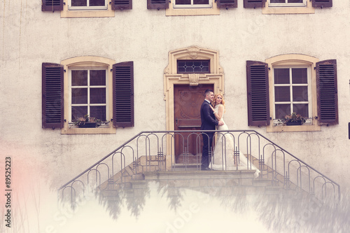 Bridal couple on stairs of their house © hreniuca