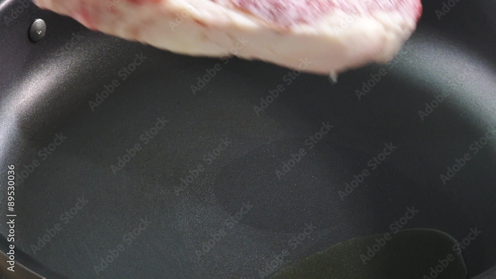 Frying T-bone steak in a frying pan Frying T-bone steak in a frying pan