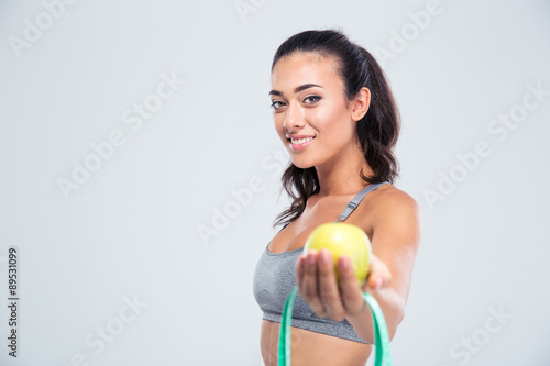 Sports woman holding apple and measuring type