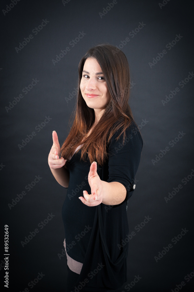 Beautiful woman doing different expressions in different sets of clothes: gun sign Beautiful woman doing different expressions in different sets of clothes: gun sign