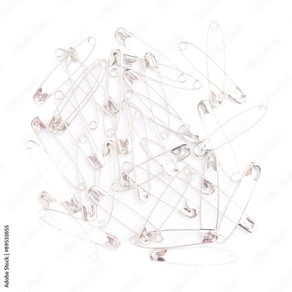 Fototapeta premium Surface covered with multiple safety pins isolated on white