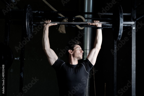 Athlete Fitness trainer working out / weight lifting in a gym