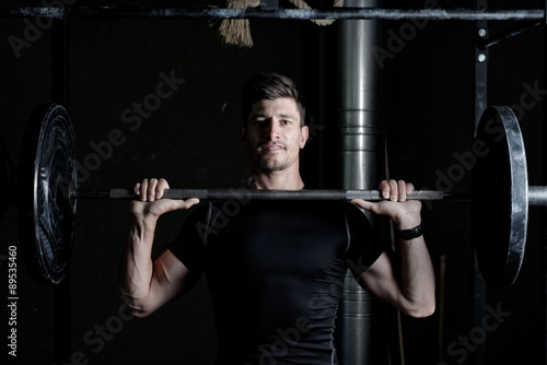 Athlete Fitness trainer working out / weight lifting in a gym