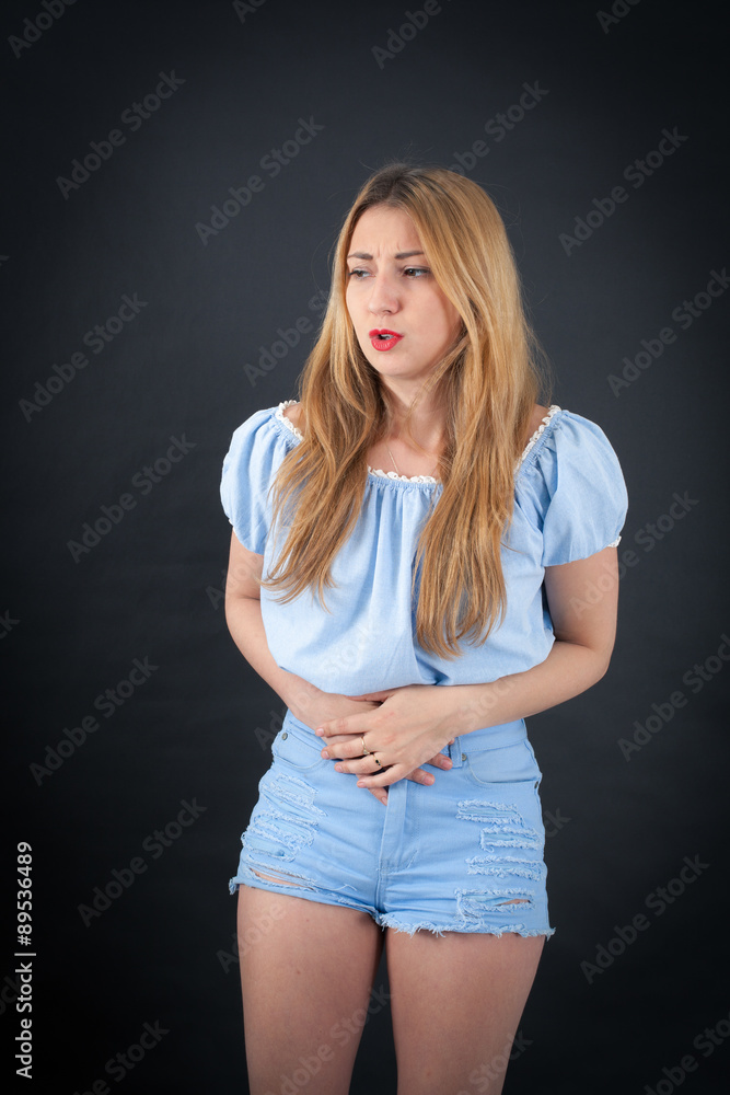 Beautiful girl doing different expressions in different sets of clothes: stomachache Beautiful girl doing different expressions in different sets of clothes: stomachache