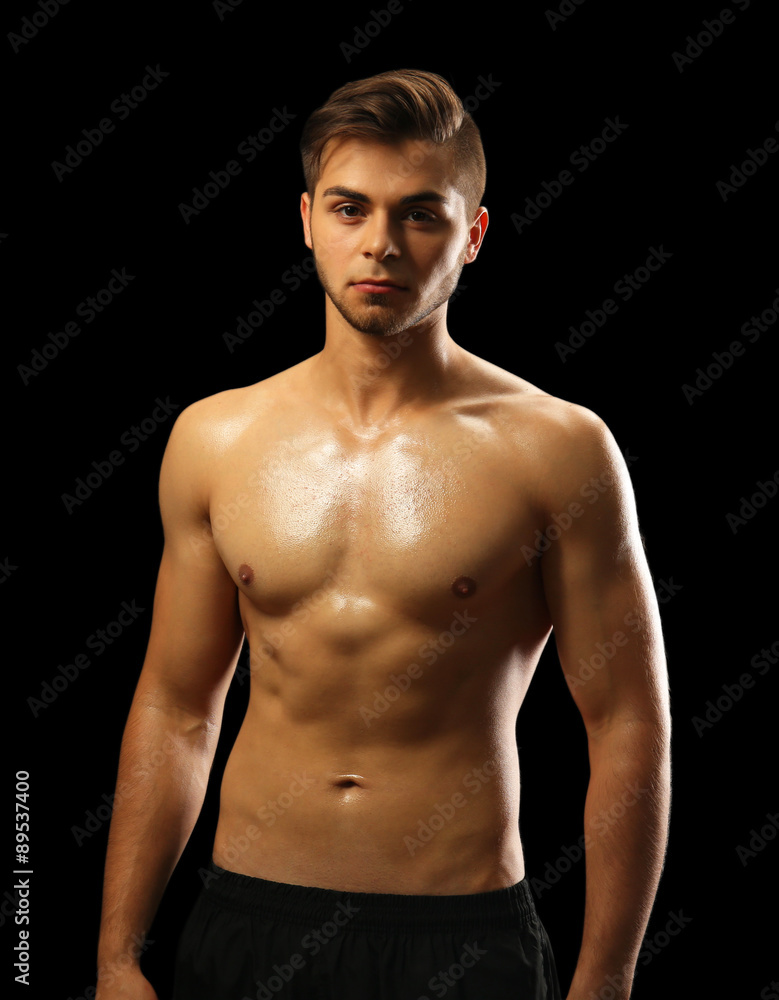 Fototapeta premium Muscle young man on dark background