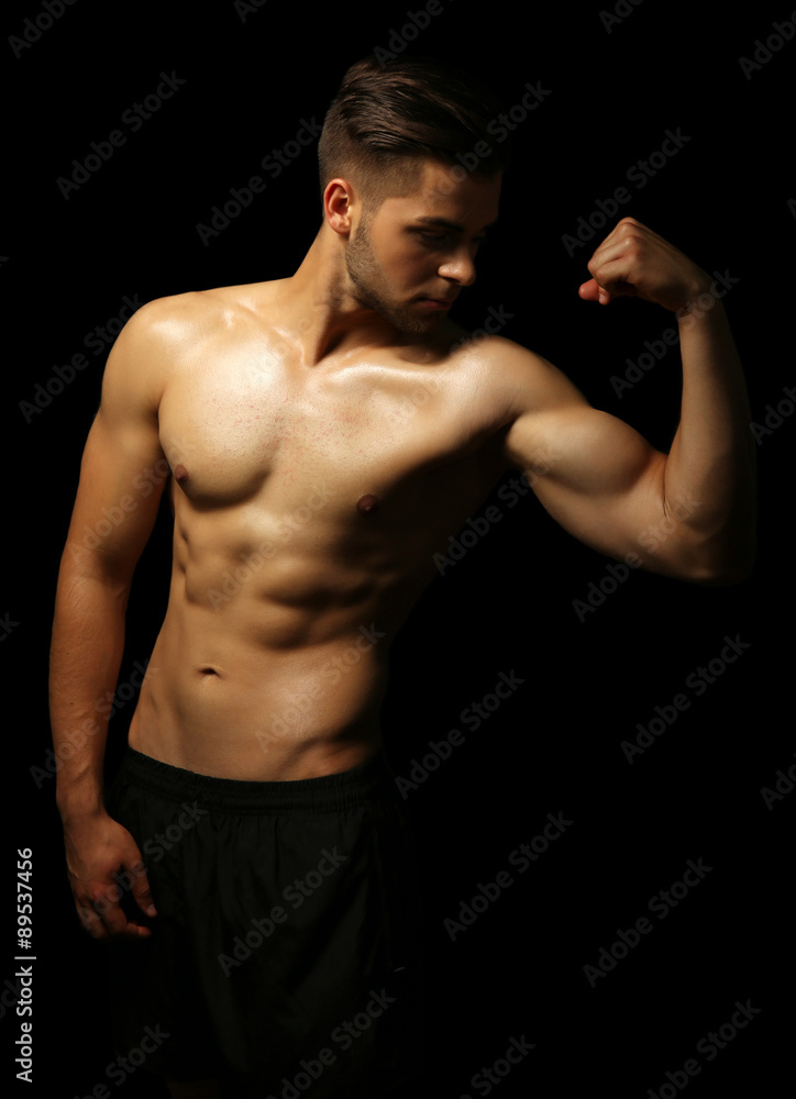 Muscle young man on dark background