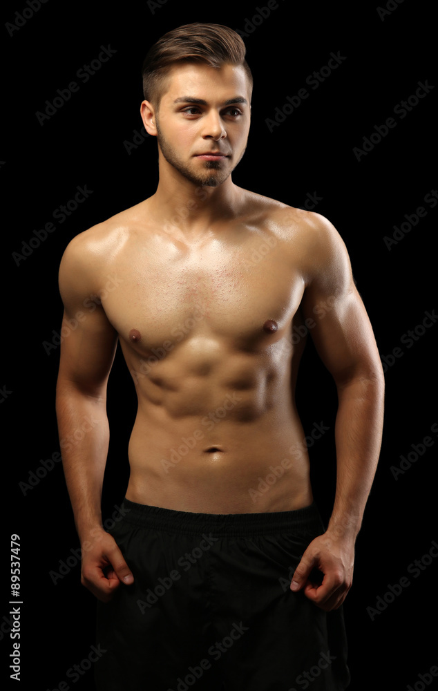 Fototapeta premium Muscle young man on dark background
