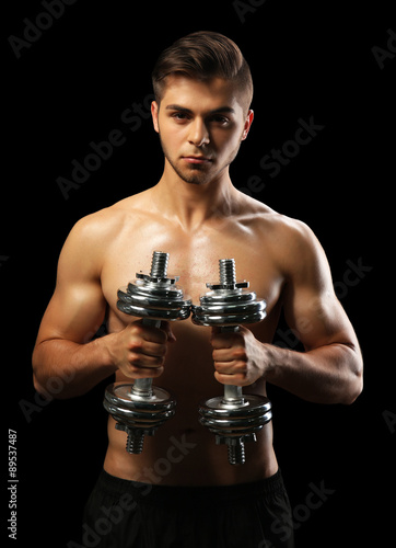 Muscle young man holding du...