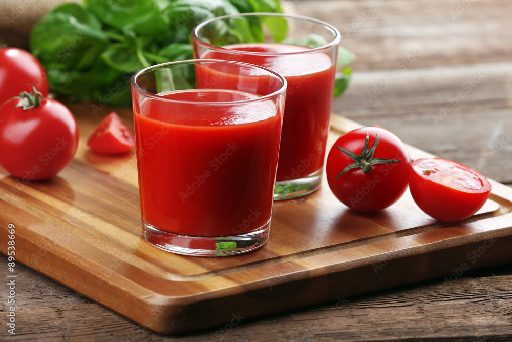 Glasses of tomato juice on wooden table, closeup Glasses of tomato juice on wooden table, closeup