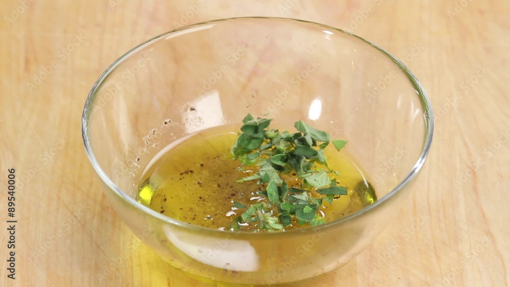 Oregano leaves being added to dressing Oregano leaves being added to dressing