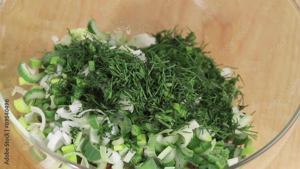 Dill being added to finely chopped spring onions Dill being added to finely chopped spring onions