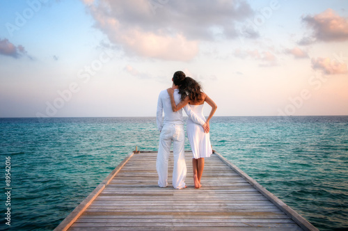 Sensual love couple on a jetty on Maldives photo
