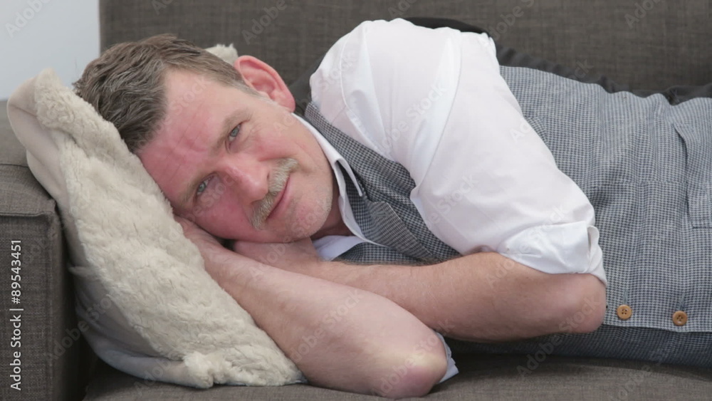businessman sleeping on couch,waking up and smiling at camera businessman sleeping on couch,waking up and smiling at camera
