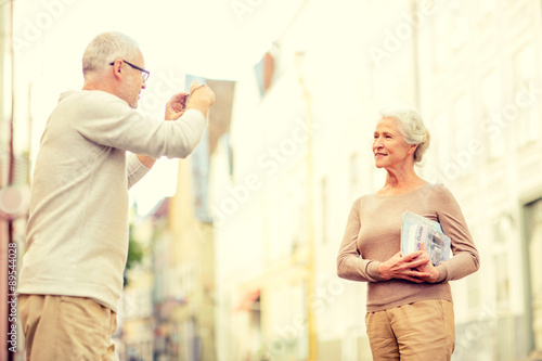 senior couple photographing on city street