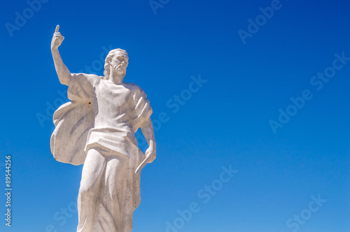 A statue of St Elijah the prophet holding a knife on a blue sky