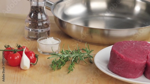 Beef fillet steaks, herbs, spices, a pan and oil photo