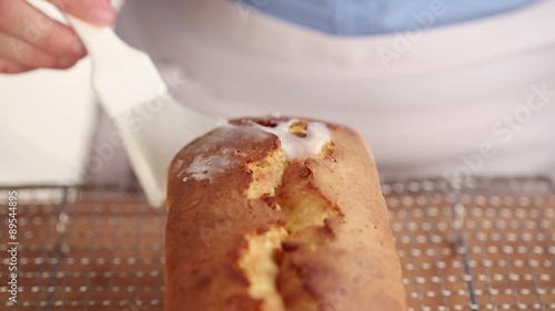 A loaf cake being brushed with icing sugar photo