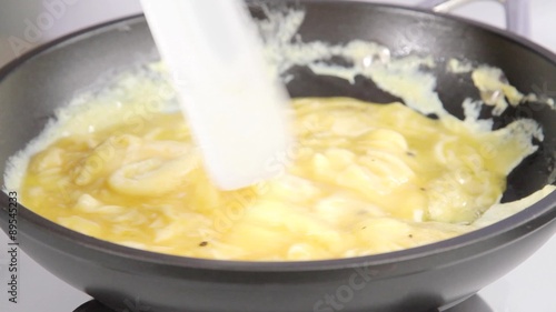 Beaten eggs being scrambled in a pan
