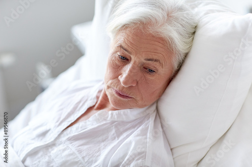 senior woman patient lying in bed at hospital ward photo