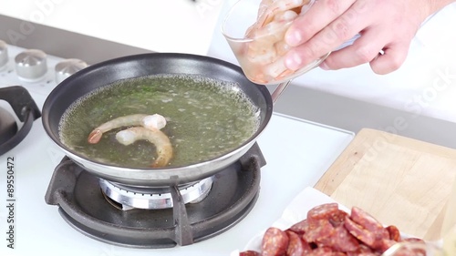 Peeled prawns being added to boiling vegetable stock photo