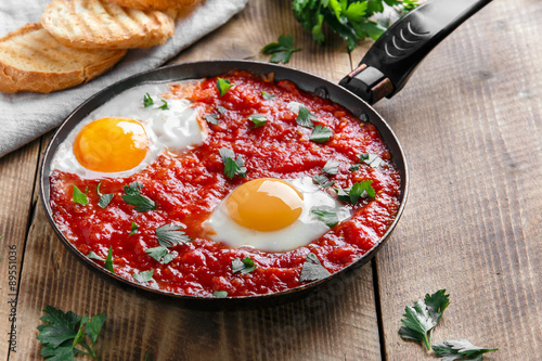 fried eggs in tomato sauce in the pan