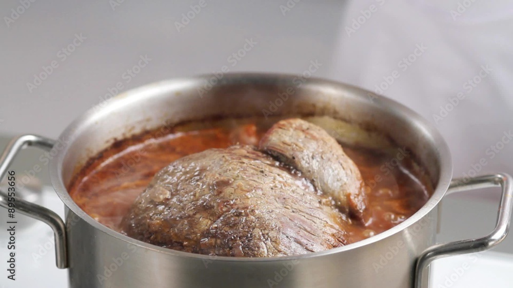 Pouring red wine over beef for braising Pouring red wine over beef for braising