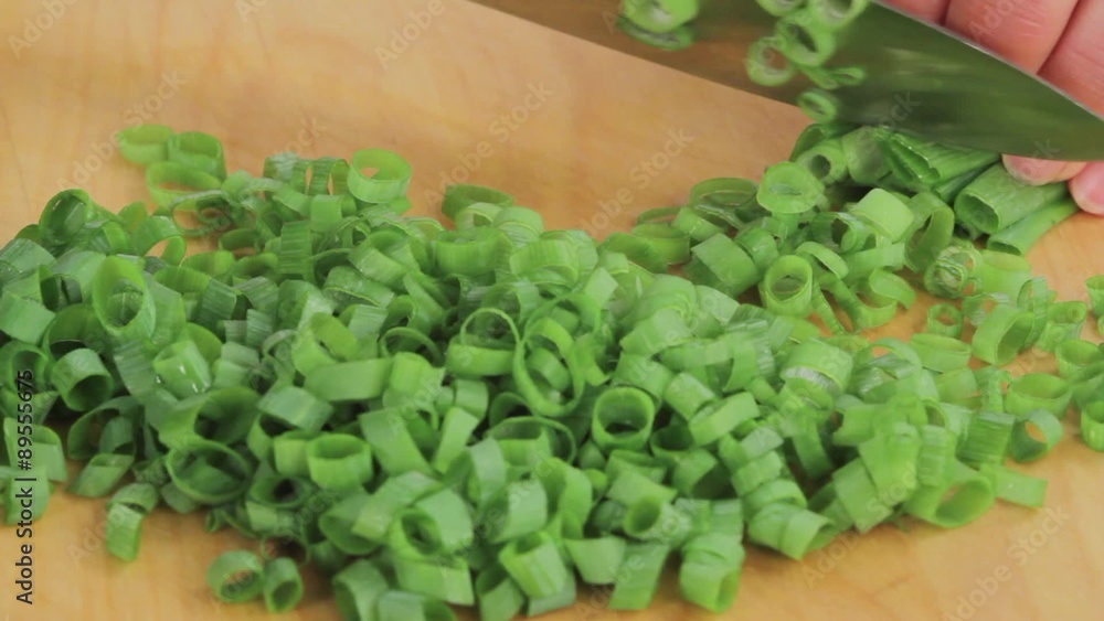 Chopping spring onion leaves into fine rings