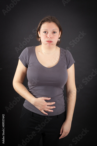 Beautiful woman doing different expressions in different sets of clothes: stomachache