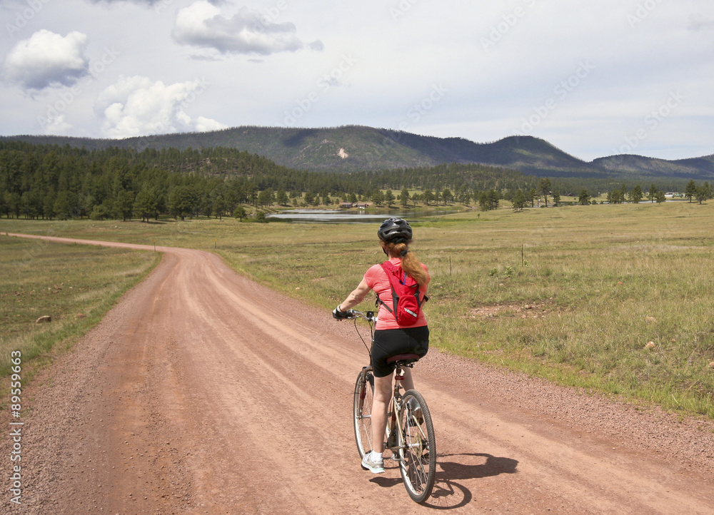 A Woman Cyclist Rides a Forest Road