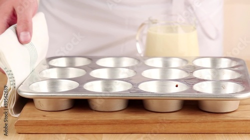 Yorkshire pudding batter being poured into a muffin tin