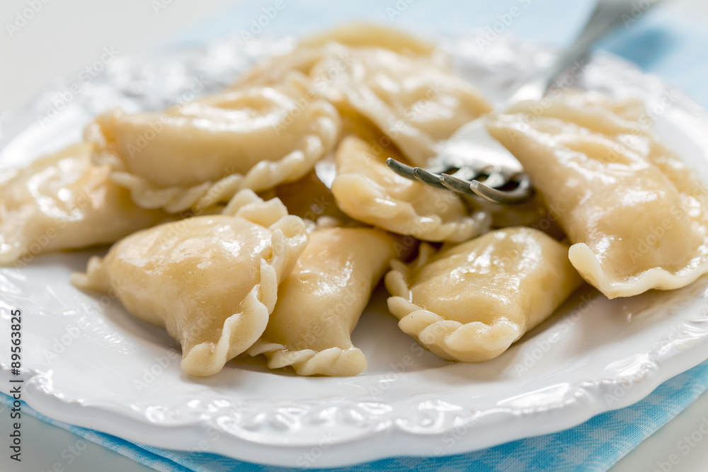 Dumplings with cottage cheese and fork on the plate.