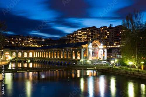 The BFM (Batiment des Forces Motrices) and the Rhone river at the blue hour, Geneva, Switzerland. This state owned building was formerly a power generating plant, it is now an opera house.