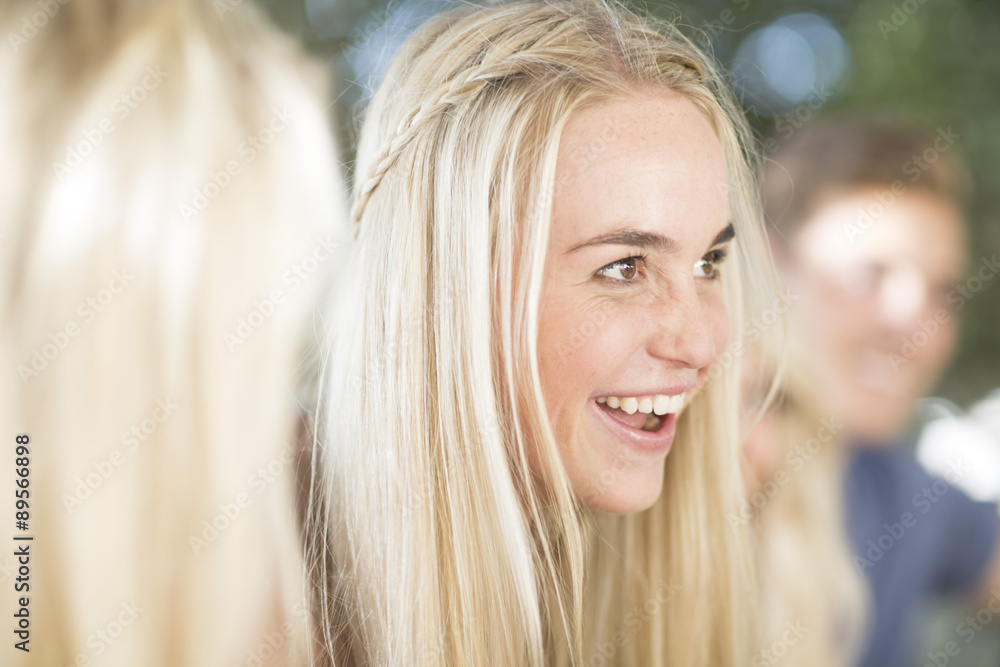 Smiling young woman among friends outdoors Smiling young woman among friends outdoors